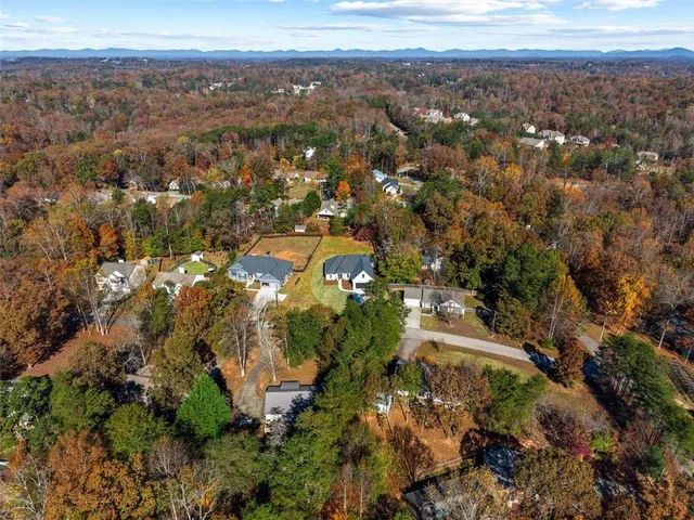 an aerial view of a house with a yard and ocean view