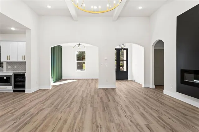 a spacious bedroom with a bed a couch and a chandelier