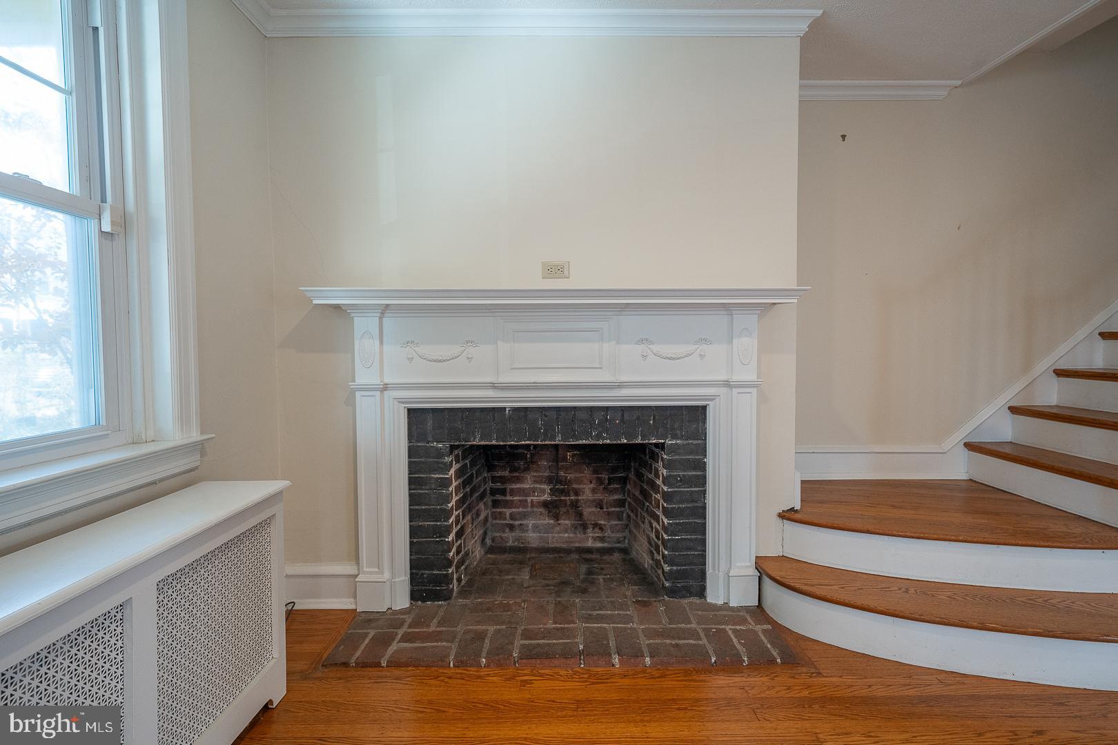 2939 Berkley Road Ardmore, PA 19003 - Photo 6 of 37 a living room with a fireplace and a floor to ceiling window