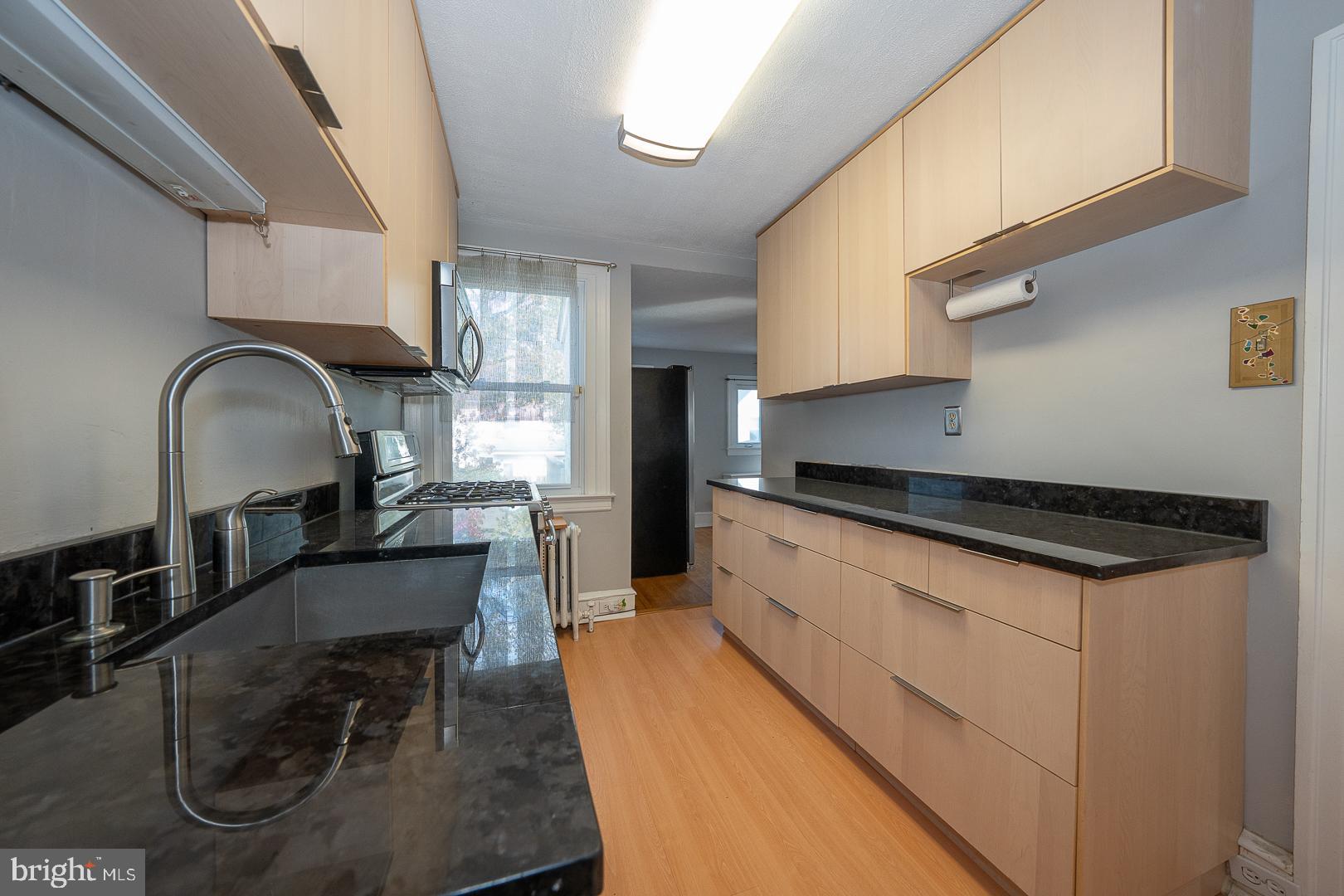 2939 Berkley Road Ardmore, PA 19003 - Photo 8 of 37 a kitchen with stainless steel appliances granite countertop a stove a sink a refrigerator and a dining table with wooden floor