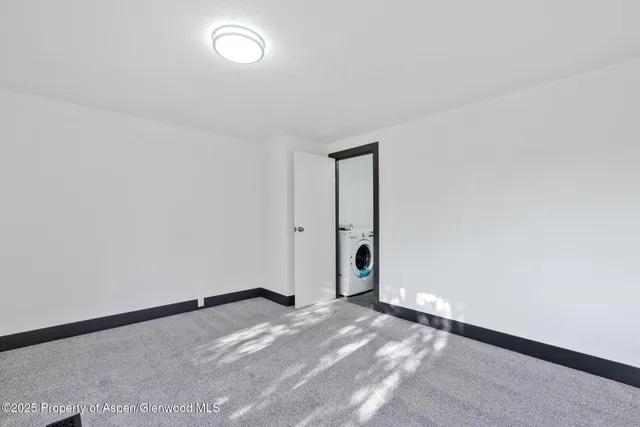 a view of a big room with wooden floor and a kitchen