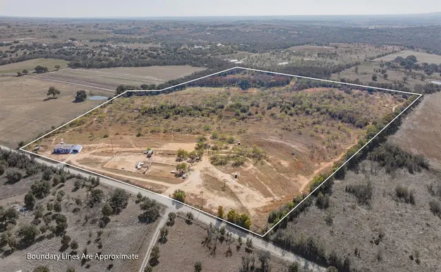a view of a dry yard with wooden fence