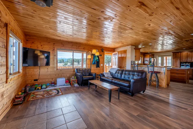 a living room with furniture a wooden floor and next to a window