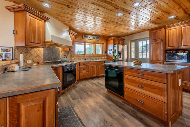 a kitchen with stainless steel appliances granite countertop sink stove top oven and cabinets