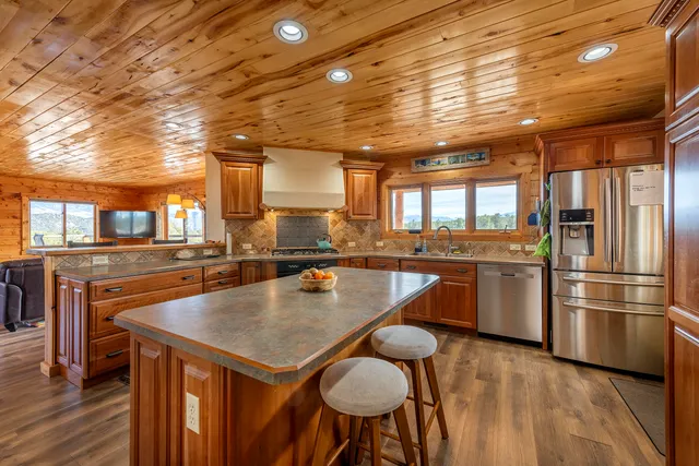 a kitchen with a table chairs refrigerator and cabinets