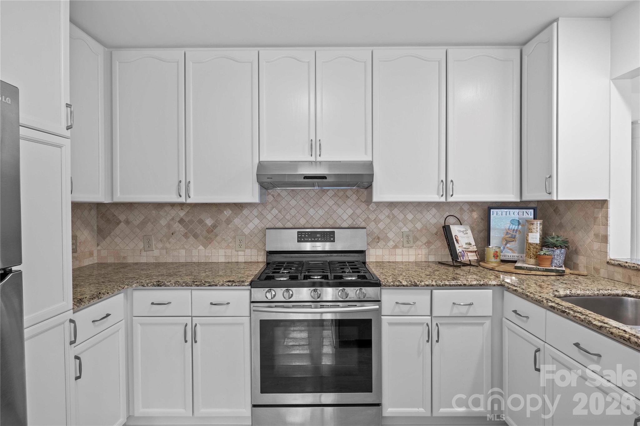21133 Rio Oro Drive Cornelius, NC 28031 - Photo 18 of 41 a kitchen with granite countertop white cabinets and white appliances