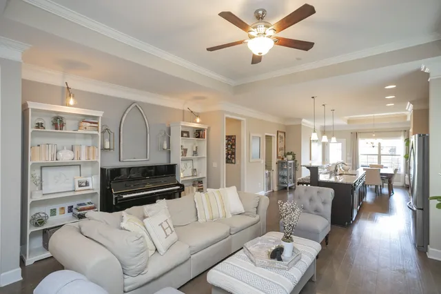 a living room with furniture ceiling fan and a wooden floor