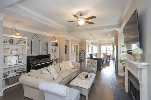a living room with furniture a fireplace and a chandelier