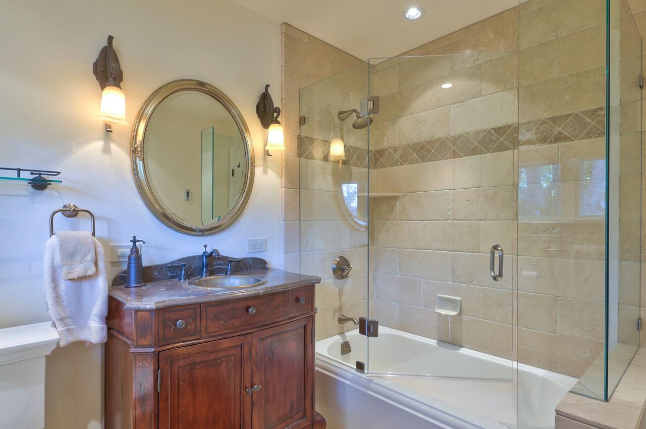 3115 Middle Ranch Road Pebble Beach, CA 93953 - Photo 11 of 15 a bathroom with a granite countertop sink a mirror and a shower