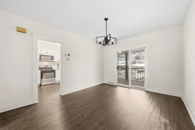 a view of a room with wooden floor a ceiling fan and a window