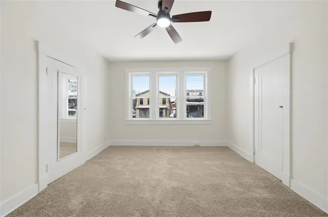 an empty room with closet and windows