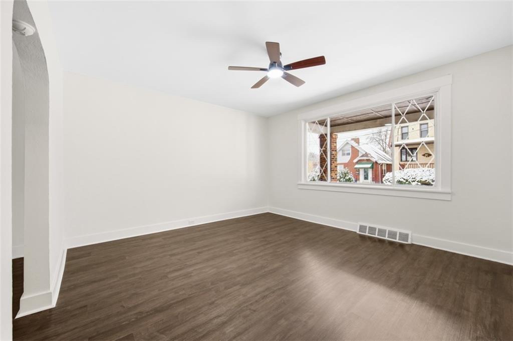 127 Duffland Street Pittsburgh, PA 15210 - Photo 10 of 36 an empty room with wooden floor fan and windows