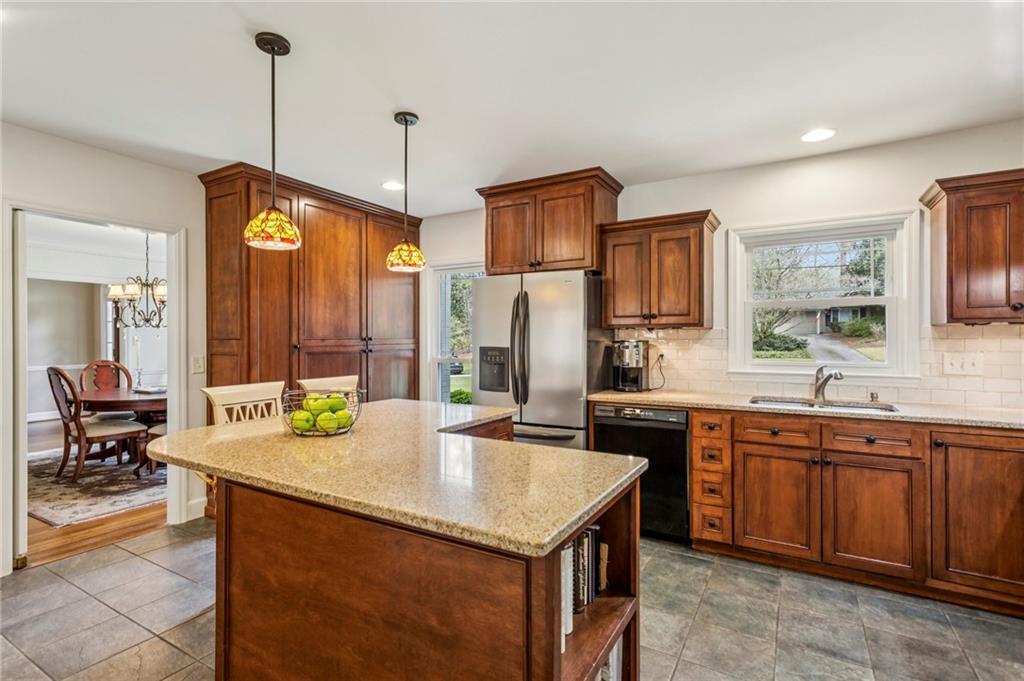 3384 Pine Meadow Road Northwest Atlanta, GA 30327 - Photo 21 of 56 a kitchen with kitchen island granite countertop a sink a counter top space appliances and cabinets