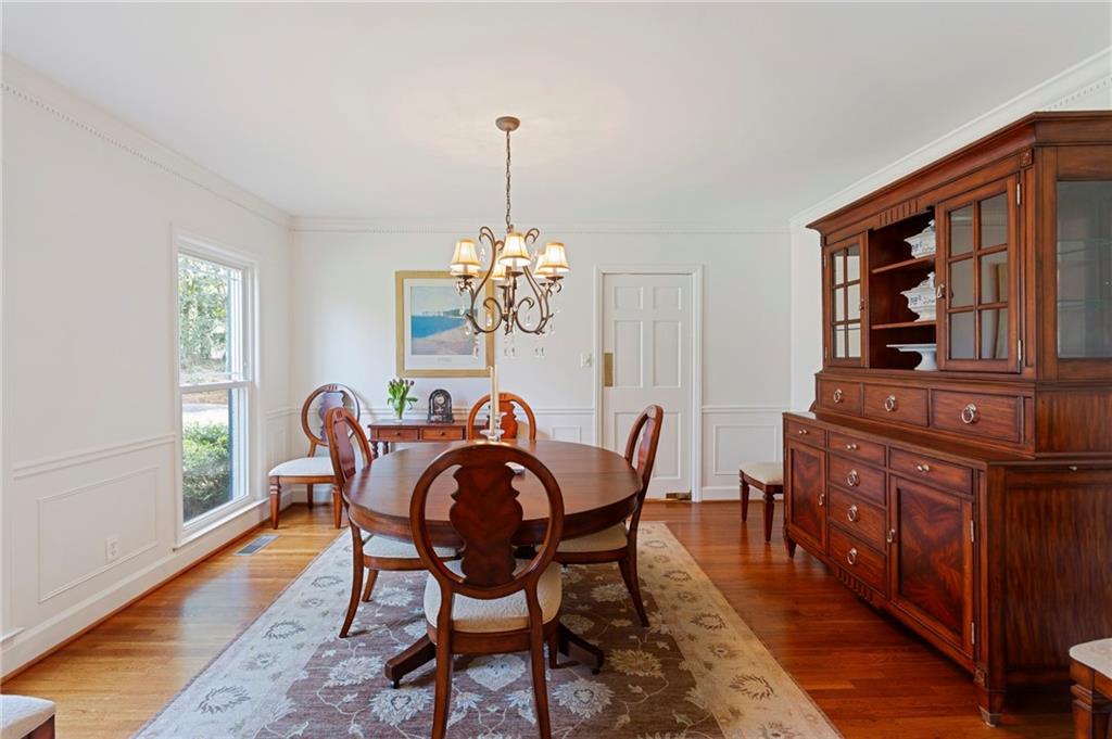 3384 Pine Meadow Road Northwest Atlanta, GA 30327 - Photo 7 of 56 a dining room with furniture a chandelier and wooden floor