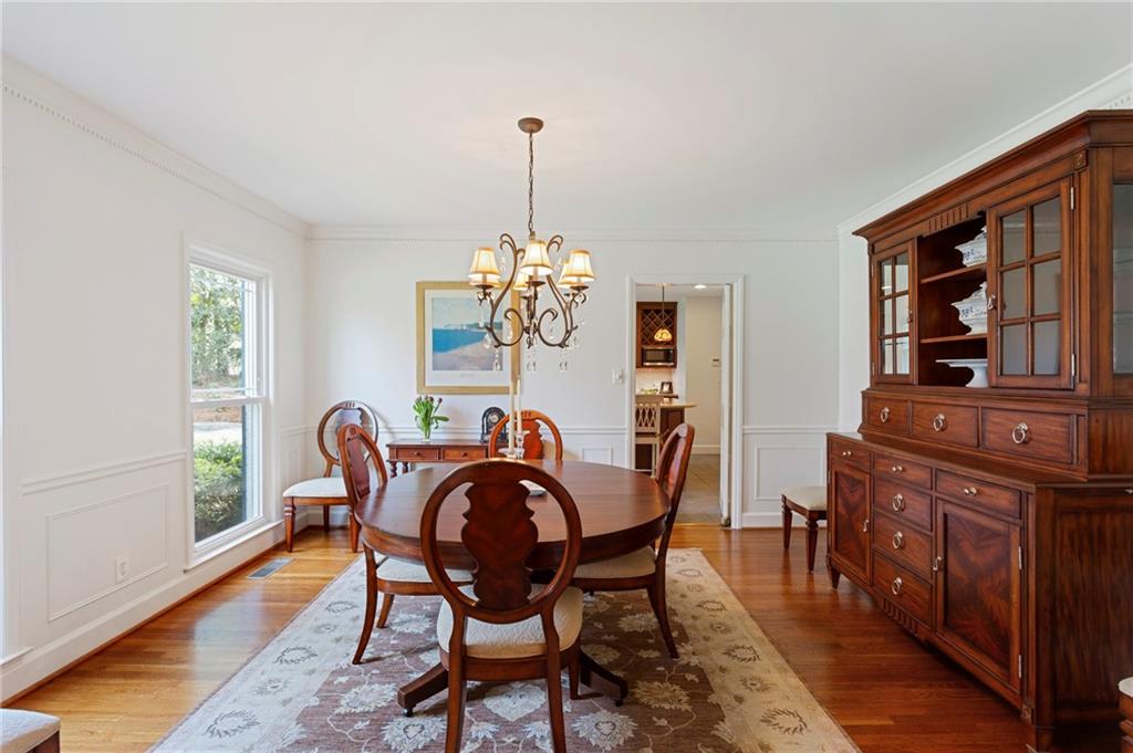 3384 Pine Meadow Road Northwest Atlanta, GA 30327 - Photo 8 of 56 a dining room with furniture a chandelier and wooden floor