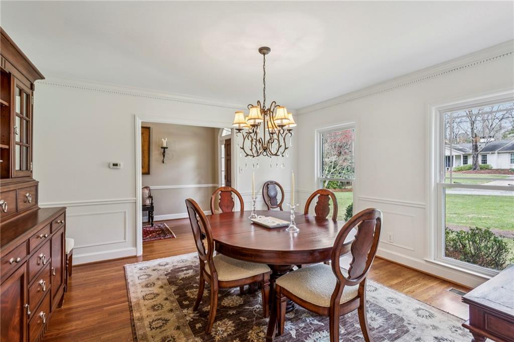3384 Pine Meadow Road Northwest Atlanta, GA 30327 - Photo 9 of 56 a dining room with furniture a chandelier and wooden floor