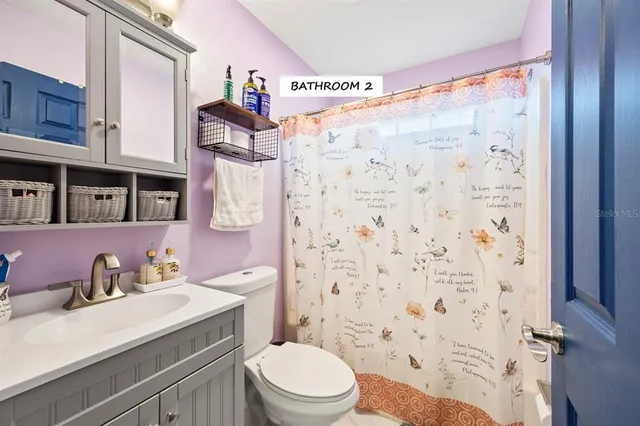 a bathroom with a sink toilet vanity and shower