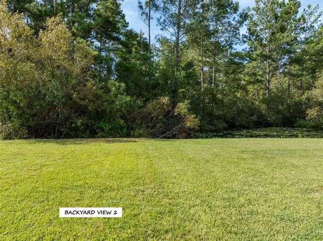 an aerial view of a house with a garden and lake view