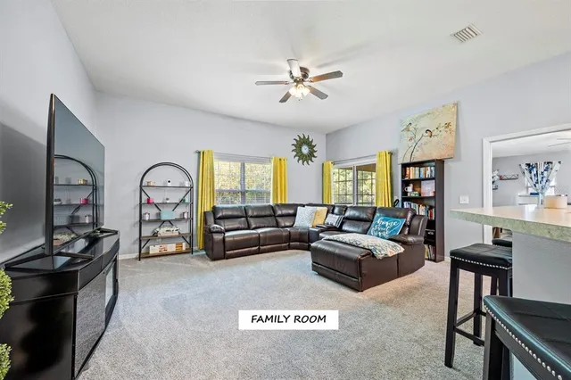 a living room with furniture a window and a flat screen tv