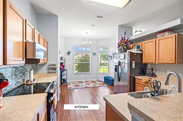 a kitchen with sink refrigerator and large window