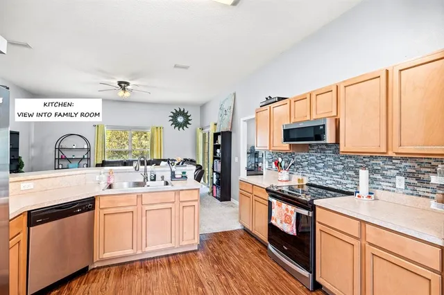 a kitchen with stainless steel appliances a sink cabinets and wooden floor