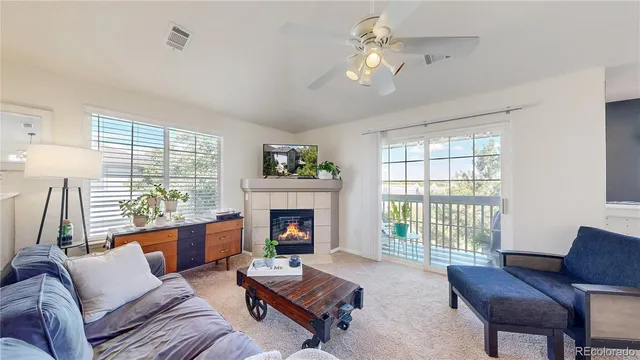 a living room with furniture fireplace and a large window