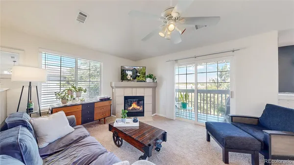 a living room with furniture fireplace and a large window