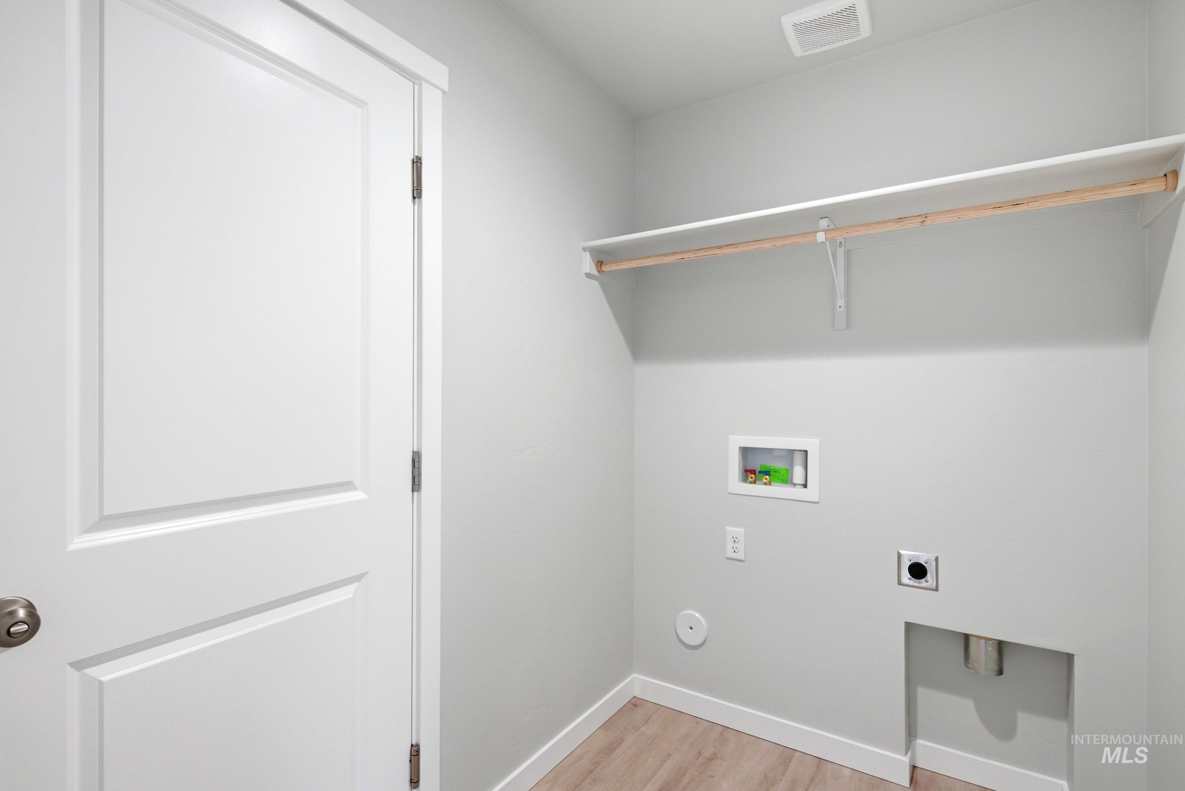 16632 North Shorthorn Loop Nampa, ID 83651 - Photo 14 of 17 Utility space featuring light wood-finish flooring, a white two-panel door, and a built-in shelf with a hanging rod