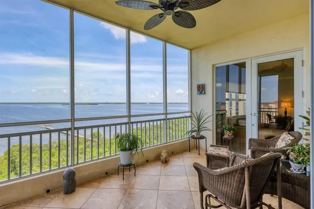 a spacious bedroom with a bed a couch and a chandelier