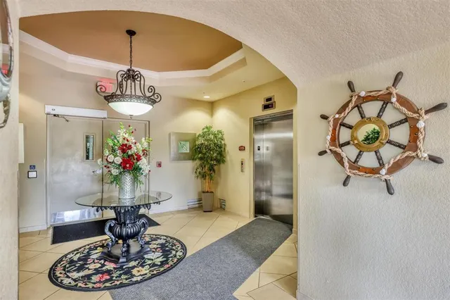 a view of a hallway with furniture and a chandelier