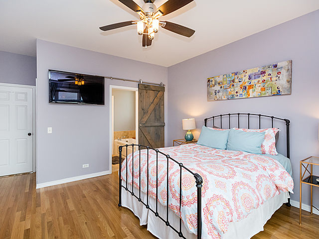 2127 West Rice Street, Unit 4E Chicago, IL 60622 - Photo 13 of 23 a bedroom with a bed and a flat screen tv
