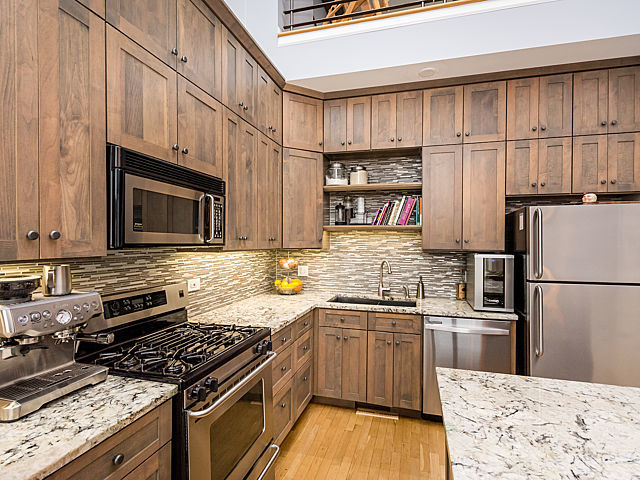 2127 West Rice Street, Unit 4E Chicago, IL 60622 - Photo 10 of 23 a kitchen with stainless steel appliances granite countertop a stove top oven a sink dishwasher and a refrigerator with wooden floor