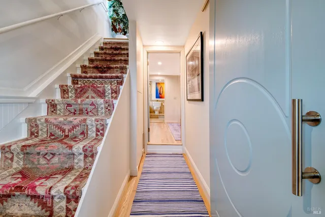 a view of a hallway with wooden floor and entryway