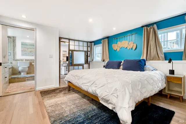 a bed sitting in a spacious bedroom next to a window