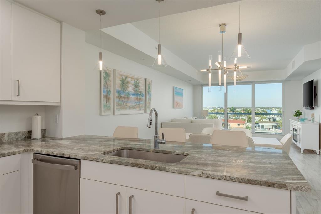 415 Island Way, Unit 402 Clearwater Beach, FL 33767 - Photo 13 of 35 a view of a kitchen with granite countertop stainless steel appliances and a counter space