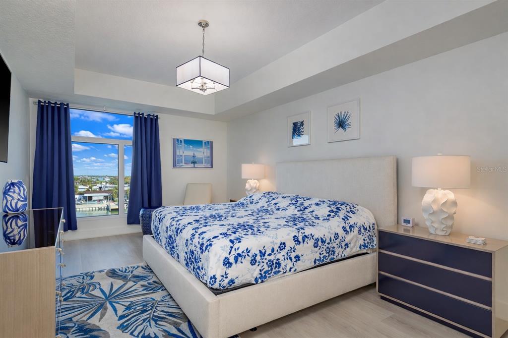 415 Island Way, Unit 402 Clearwater Beach, FL 33767 - Photo 20 of 35 a bedroom with a large bed chandelier and a window