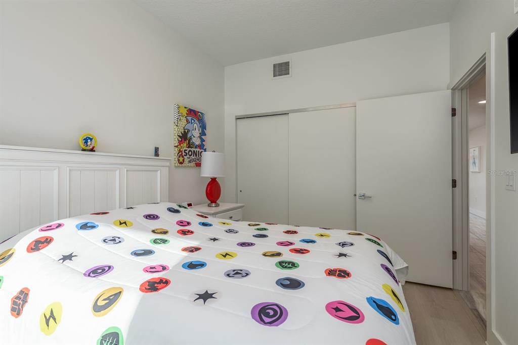 415 Island Way, Unit 402 Clearwater Beach, FL 33767 - Photo 25 of 35 a bedroom with a bed and a dresser in it