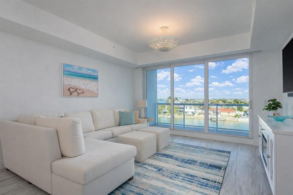 415 Island Way, Unit 402 Clearwater Beach, FL 33767 - Photo 5 of 35 a living room with furniture and a floor to ceiling window