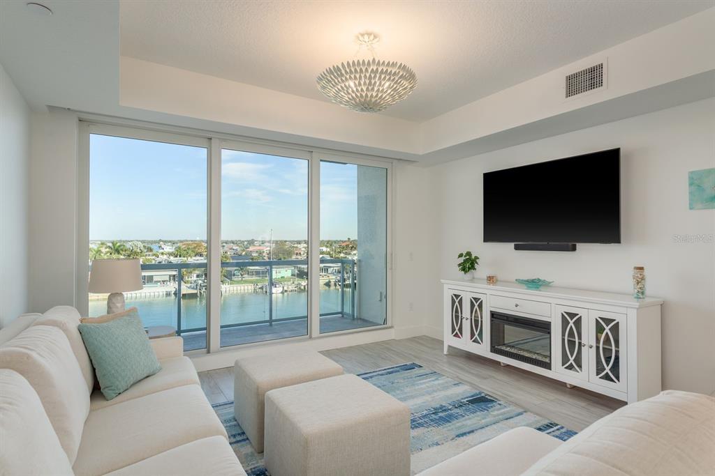 415 Island Way, Unit 402 Clearwater Beach, FL 33767 - Photo 6 of 35 a living room with furniture and a flat screen tv