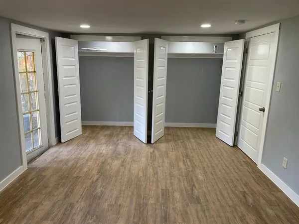 an empty room with wooden floor and entrance