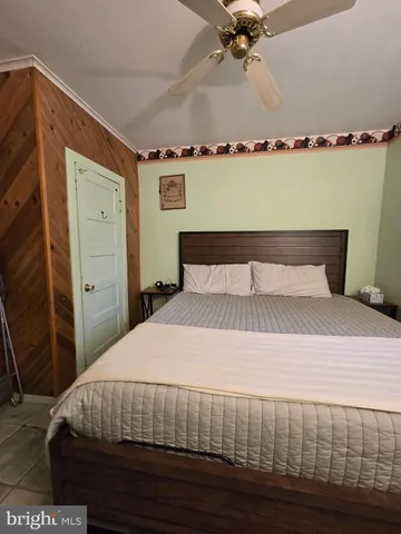 a bedroom with a bed and a ceiling fan