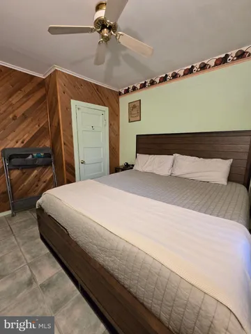 a bedroom with a large bed and a ceiling fan
