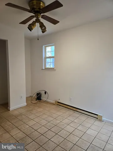 a room with a hanging light and hardwood