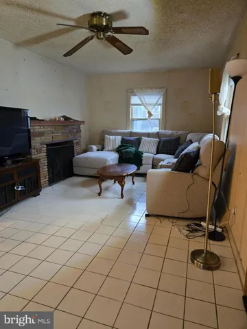 a living room with furniture a flat screen tv and a window