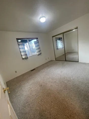 an empty room with windows and mirror