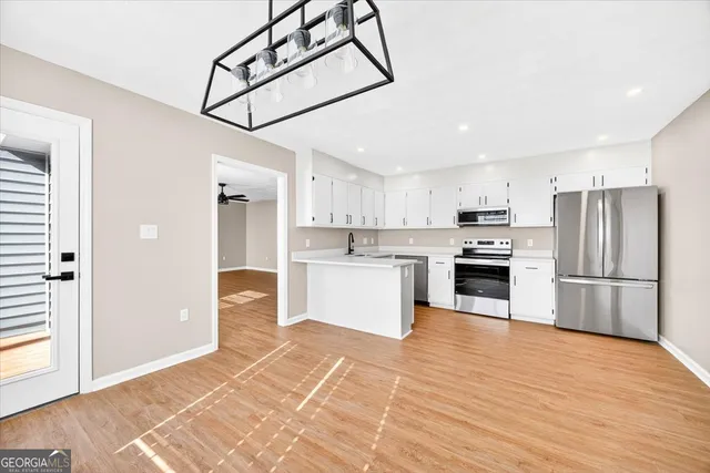 a view of empty room with wooden floor and ceiling fan