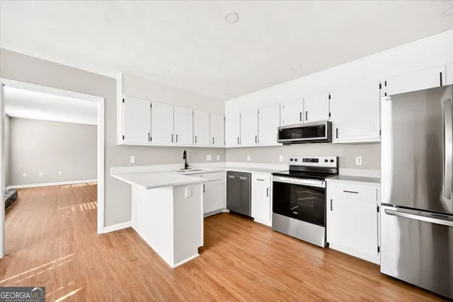 a kitchen with stainless steel appliances a sink a stove and cabinets