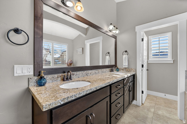 14714 South Bright Wood Road Herriman, UT 84096 - Photo 23 of 41 Primary en-suite bath featuring double vanity, light tile patterned floors, and vaulted ceiling