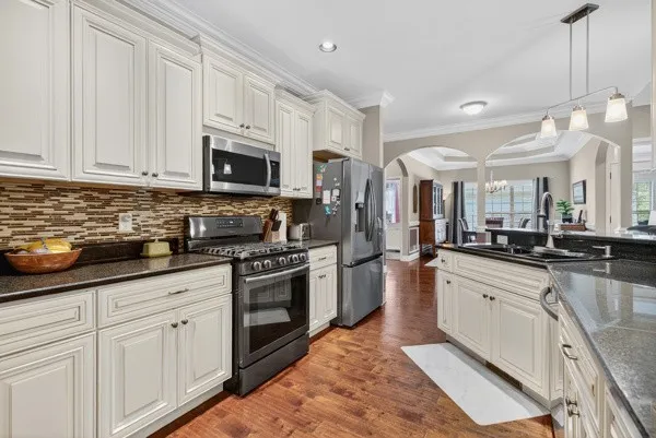 a large kitchen with cabinets stainless steel appliances and a sink