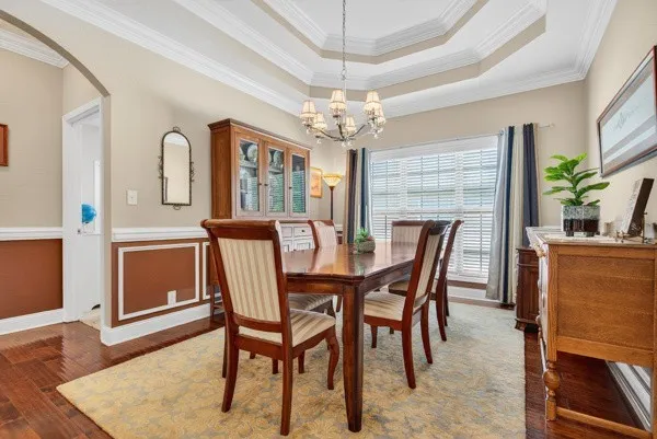 a dining room with furniture a chandelier and wooden floor